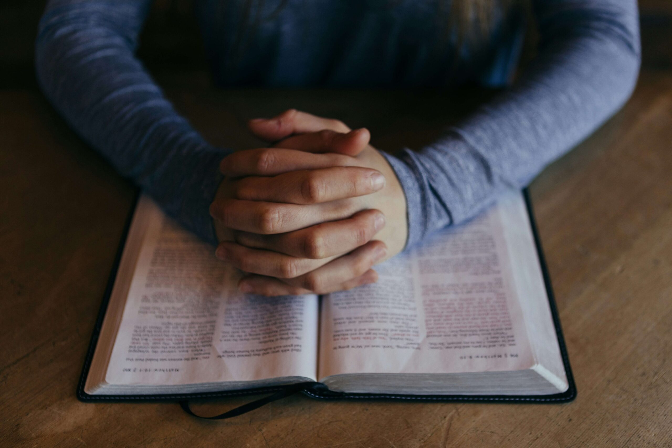 person praying and reading the bible